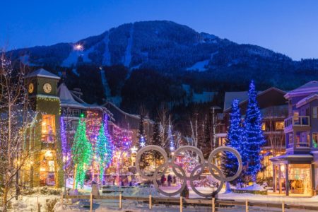 View of Whistler Mountain with Whistler Village lit with Christmas fairy lights with the Brewhouse Pub in the foreground.